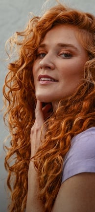 Woman with healthy looking and naturally curly red hair