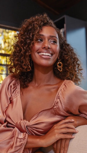 Woman with curly hair and purple hair color